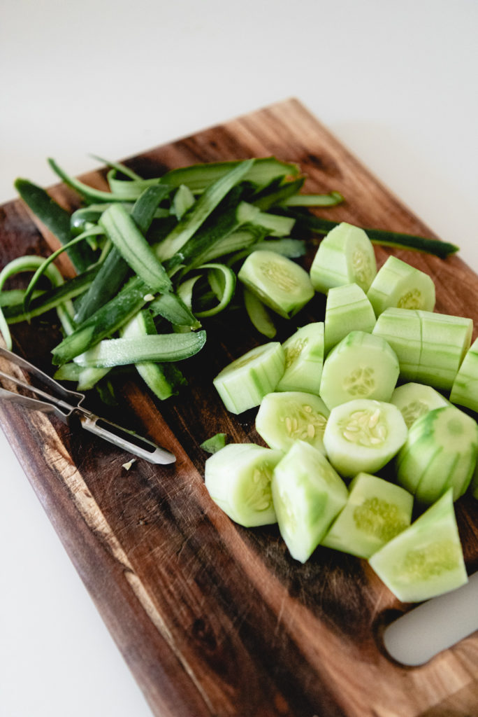 skinned and sliced cucumbers on cutting board