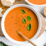 tomato soup with basil garnish and crusty bread