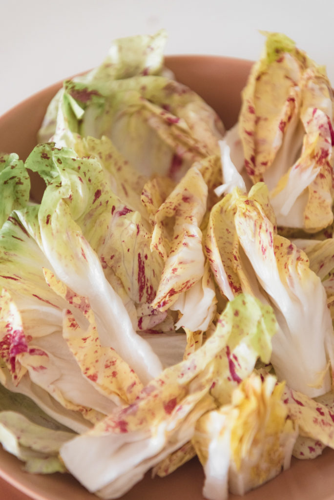 pink radicchio leaves in a terra cotta bowl