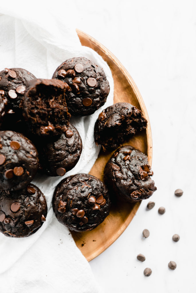chocolate zucchini muffins on white background with chocolate chips